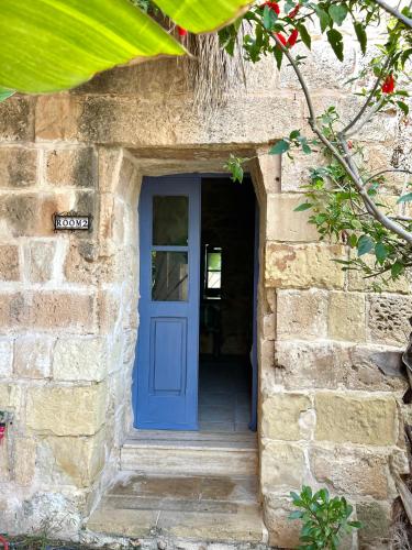 a blue door in a stone building with a stairs at Ta Skorba Farmhouse Mgarr in Mġarr