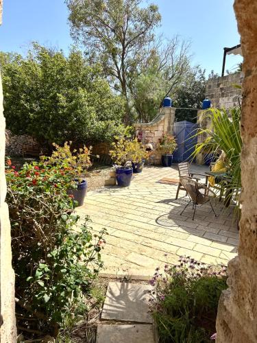 a patio with a table and chairs and plants at Ta Skorba Farmhouse Mgarr in Mġarr
