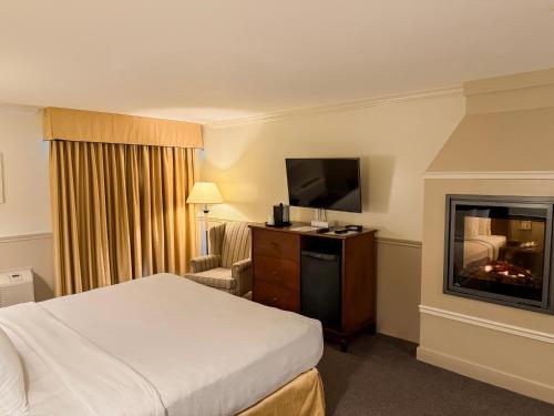 a hotel room with a bed and a fireplace at Inn on the Lake in Fall River