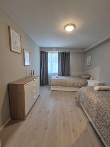 a bedroom with two beds and a dresser in it at Vakker leilighet i Åros in Søgne