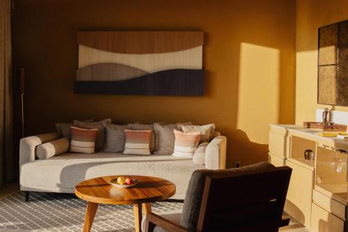 a bedroom with a bed and a coffee table at Banyan Tree Veya, Valle de Guadalupe - A Wellbeing & Wine Resort in Valle de Guadalupe