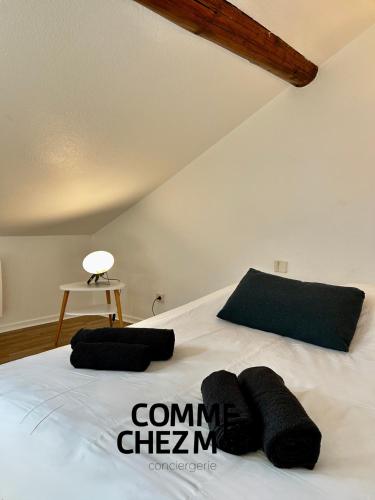 - un lit blanc avec 2 oreillers noirs dans l'établissement Studio, Le Petit Mika avec Stationnement Gratuit, à Vandœuvre-lès-Nancy