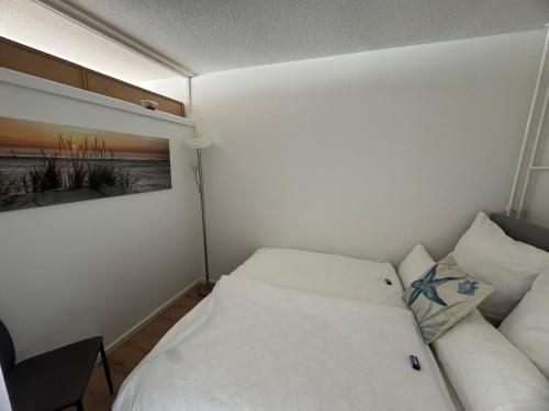 ein kleines Schlafzimmer mit einem Bett und einer Couch in der Unterkunft Ostsee Apartment mit Meerblick in Sierksdorf