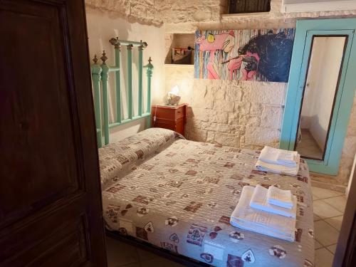 a bedroom with a bed with two towels on it at Sto al Trullo - Historic Trullo with Private Jacuzzi and Sauna in Martina Franca