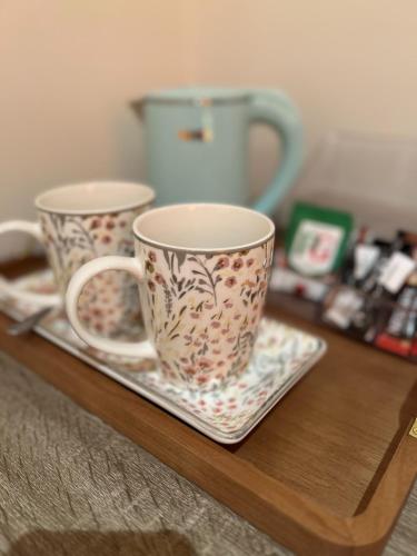 two coffee cups sitting on a wooden table at The Ingram Arms in Laughton