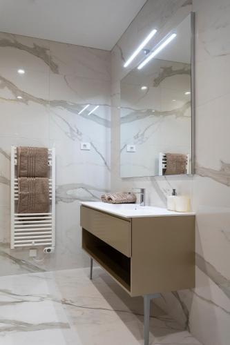 a white bathroom with a sink and a mirror at Villa EVA Resort & Boutique in Dobrovo