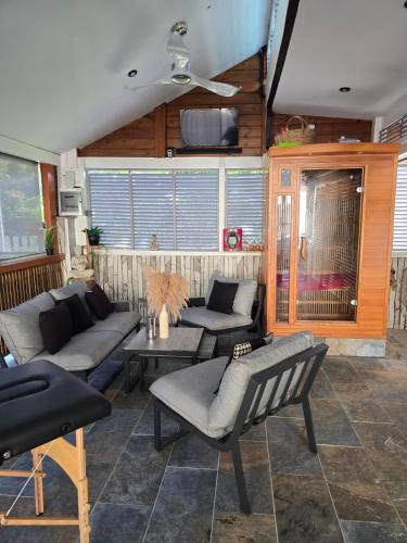 a living room with couches and a ceiling fan at Bungalow le Refuge Vert in Morne-à-lʼEau