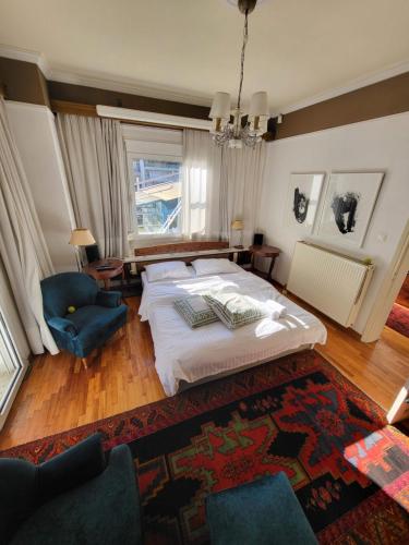 a bedroom with a large bed and a blue chair at Blue Home, Luxury Villa with Pool in the City Centre in Larisa