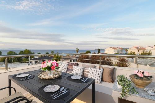 a dining table on a balcony with a view of the ocean at Marilena Mare Seaside & Jacuzzi House 50meters from sea in Ialyssos