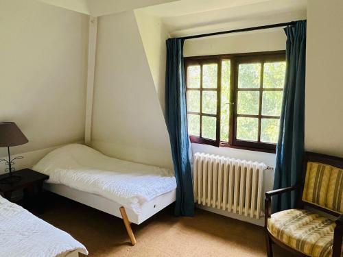 a room with two beds and a window at Authentic Norman house in Saint-Cyr-de-Salerne