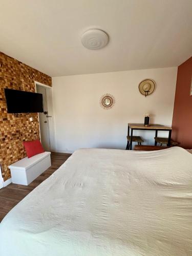 une chambre avec un lit blanc et un mur de briques dans l'établissement Studio cosy proche plage, à Fréjus