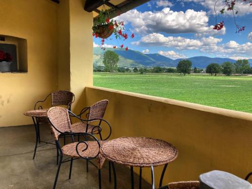 two chairs and a table on a porch with a view of a field at Agriturismo Il Casale Grande in Beroide