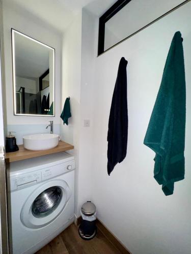 une salle de bain avec une machine à laver et un lavabo dans l'établissement Studio cosy proche plage, à Fréjus