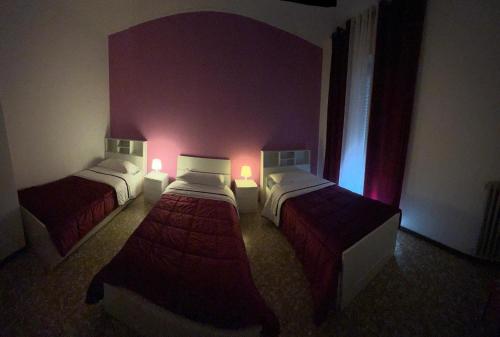two beds in a room with red lights on them at Aeroporto room in Azzano San Paolo