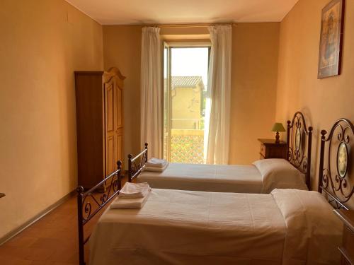 two beds in a room with a window at Agriturismo Il Casale Grande in Beroide