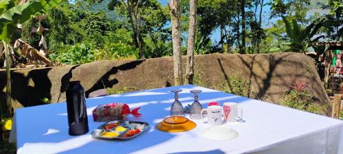 un tavolo bianco con una bottiglia di vino e del cibo sopra di Camping Cítara a Parati
