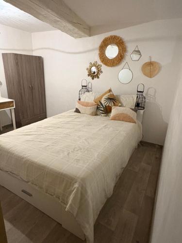 une chambre avec un grand lit et un miroir dans l'établissement Maison climatisée 4 chambres terrasse 3 kms plage, à Saint-Laurent-de-la-Salanque