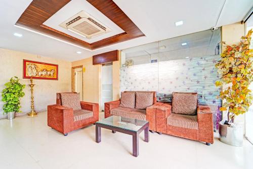 a living room with two chairs and a table at Super Collection O Gandhipuram in Coimbatore