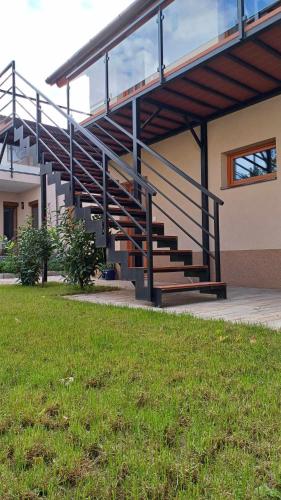 a building with a staircase next to a grass field at 4 Basa Bungalow in Szeged