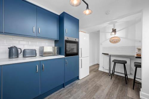 a kitchen with blue cabinets and a counter top at Luxury Modern Home Great Harwood - Sleeps Up to 8 in Great Harwood