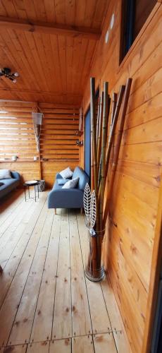 a living room with a blue couch and wooden walls at Бунгало Шангри Ла - 1, плаж Градина in Sozopol