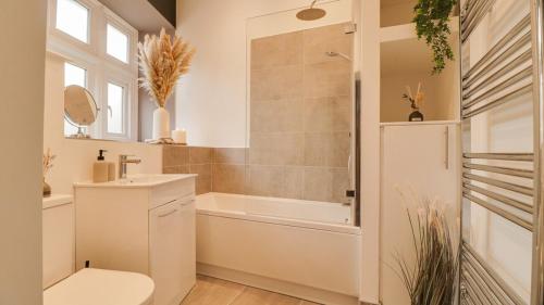 a bathroom with a toilet and a tub and a sink at The Gate House-Wyndale Living- West Malvern in Great Malvern