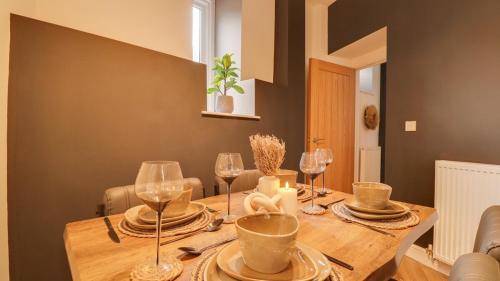 a dining room table with wine glasses and a table at The Gate House-Wyndale Living- West Malvern in Great Malvern