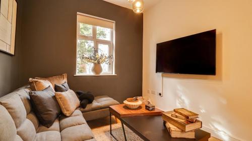 a living room with a couch and a flat screen tv at The Gate House-Wyndale Living- West Malvern in Great Malvern