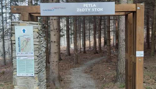 a sign for a hiking trail in the woods at Złoty Trakt pokoje i rowery in Złoty Stok