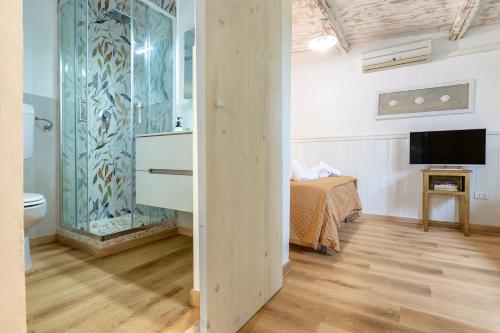 un bagno con un letto e una televisione in camera di Casa Sergio a Olbia