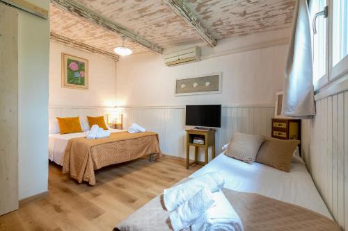 una camera con due letti e una tv di Casa Sergio a Olbia