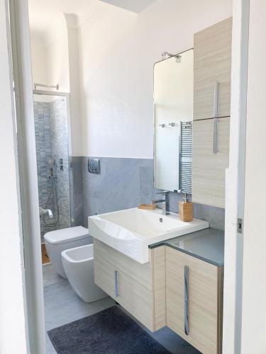 une salle de bain avec un lavabo, des toilettes et un miroir dans l'établissement Suggestivo appartamento, à Saint-Jean-Cap-Ferrat