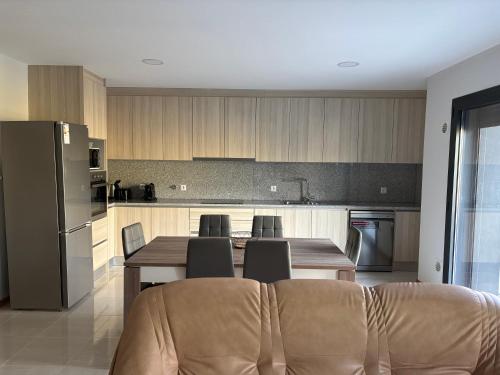 a kitchen with a table with chairs and a refrigerator at Apartamento Duplex Bragança centro in Bragança