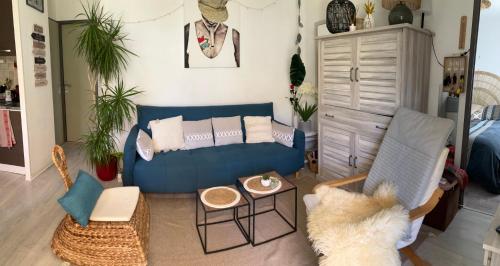 sala de estar con sofá azul y perro en Plain pied - Appartement dans résidence sous les pins, en Cap d'Agde