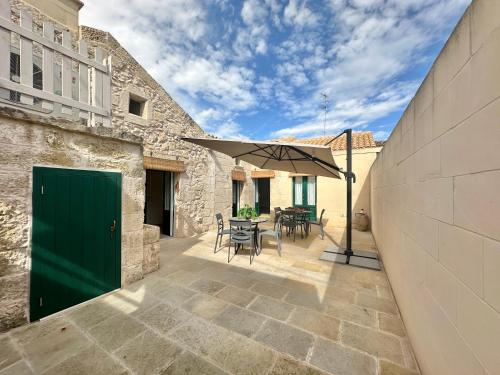 a patio with a green door and a table and chairs at Corte Ludovica in Martano