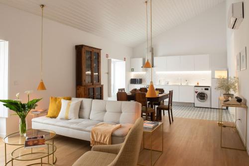a living room with a white couch and a kitchen at Vila Marta - Garça Real in Vila Franca do Campo