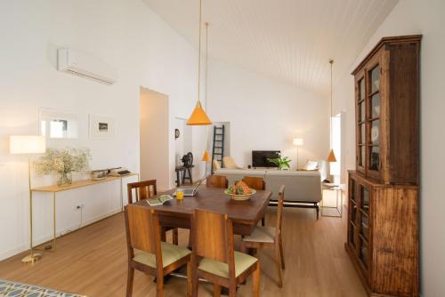 a dining room and living room with a table and chairs at Vila Marta - Garça Real in Vila Franca do Campo
