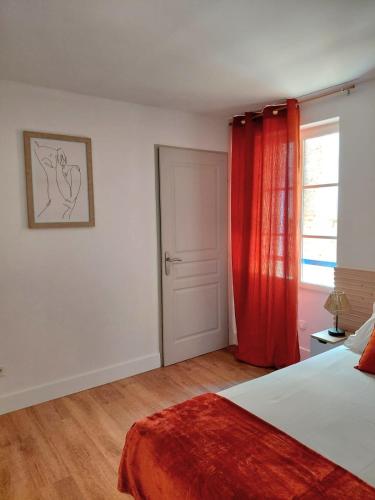 une chambre avec un lit et un rideau rouge dans l'établissement Renovated apartment, hyper center, private parking, à Perpignan