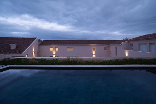 a villa with a swimming pool at night at Vila Marta - Garça Real in Vila Franca do Campo
