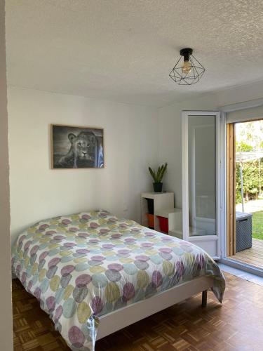 une chambre avec un lit et une porte coulissante en verre dans l'établissement Maison familiale, 4 chambres, à Tarnos