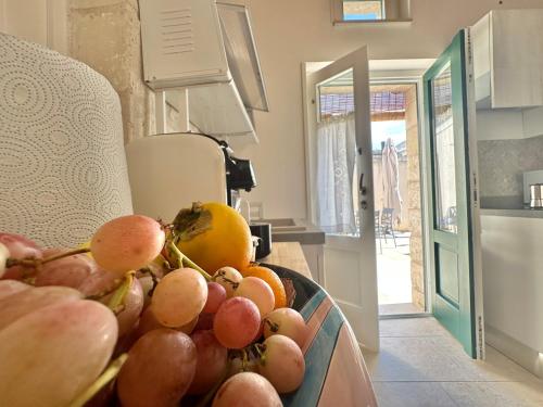 a bowl of fruit on a counter in a kitchen at Corte Ludovica in Martano