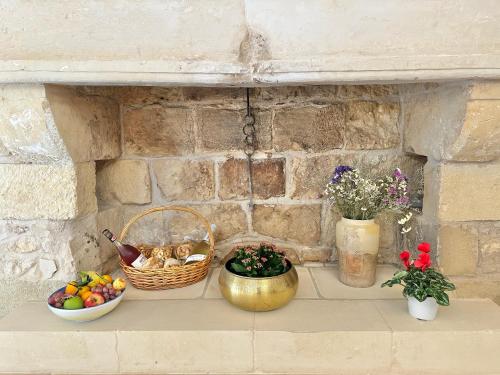 a shelf with a basket of fruit and a bowl of flowers at Corte Ludovica in Martano