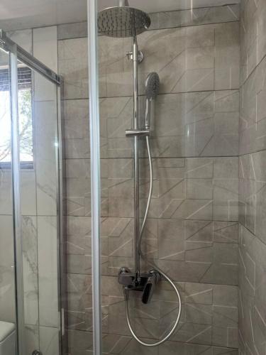 a shower with a shower head in a bathroom at Midpoint Sea and Sun in Kotor
