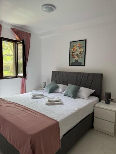 a bedroom with a large bed with towels on it at Midpoint Sea and Sun in Kotor