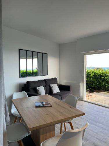 un salon avec une table en bois et un canapé dans l'établissement Horizon Bleu : Appartement Vue Mer à La Baule, à La Baule