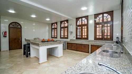 a large kitchen with a counter and a sink at Domaine Terra Cotta - Villa de luxe avec piscine sans vis-à-vis in Souk el Had