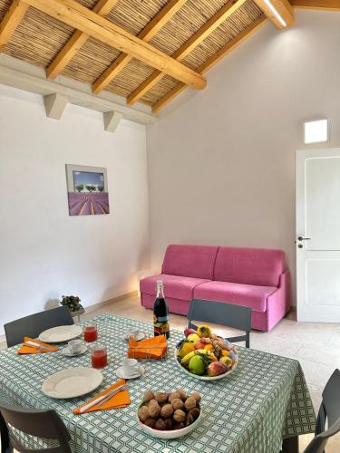 a living room with a table with a bowl of fruit at Corte Ludovica in Martano