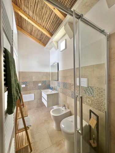 a bathroom with a toilet and a sink at Corte Ludovica in Martano