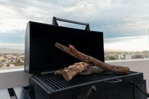 a grill with two pieces of meat and two logs at The Residences by Morgan in Cabo San Lucas