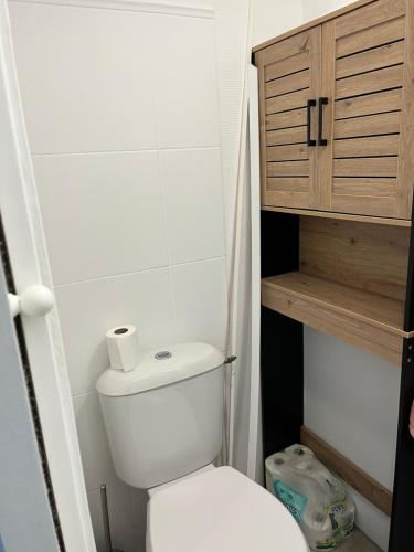 La petite salle de bains est pourvue de toilettes et d'une armoire en bois. dans l'établissement Horizon Bleu : Appartement Vue Mer à La Baule, à La Baule